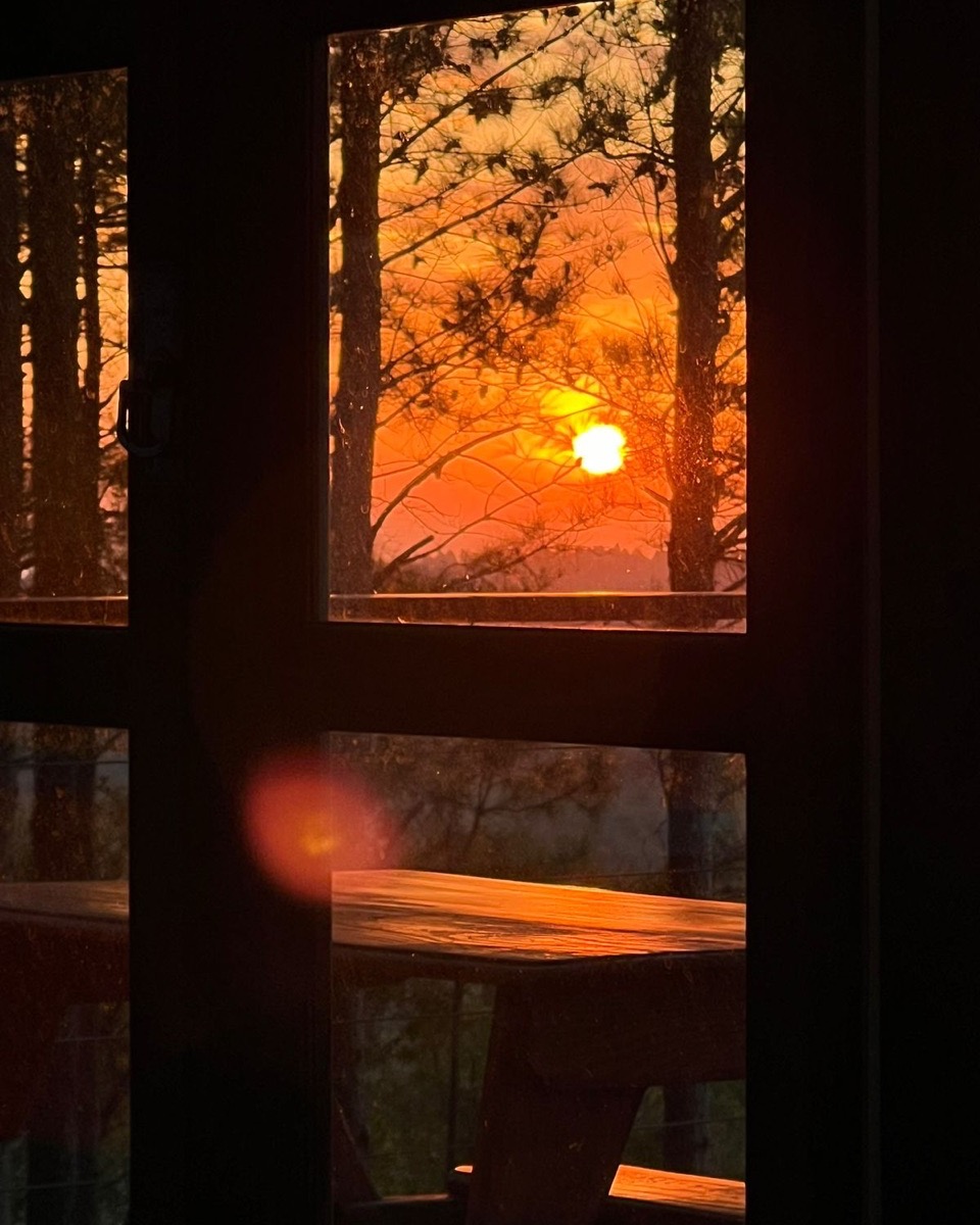 Pôr do sol visto de dentro da cabana